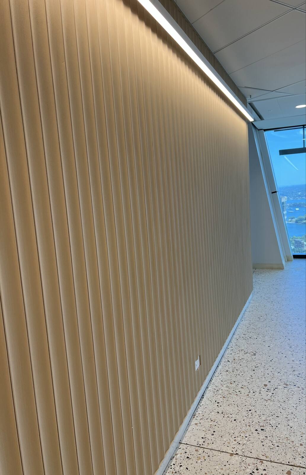 Custom fluted timber feature wall in a Sydney CBD office fitout with harbour views