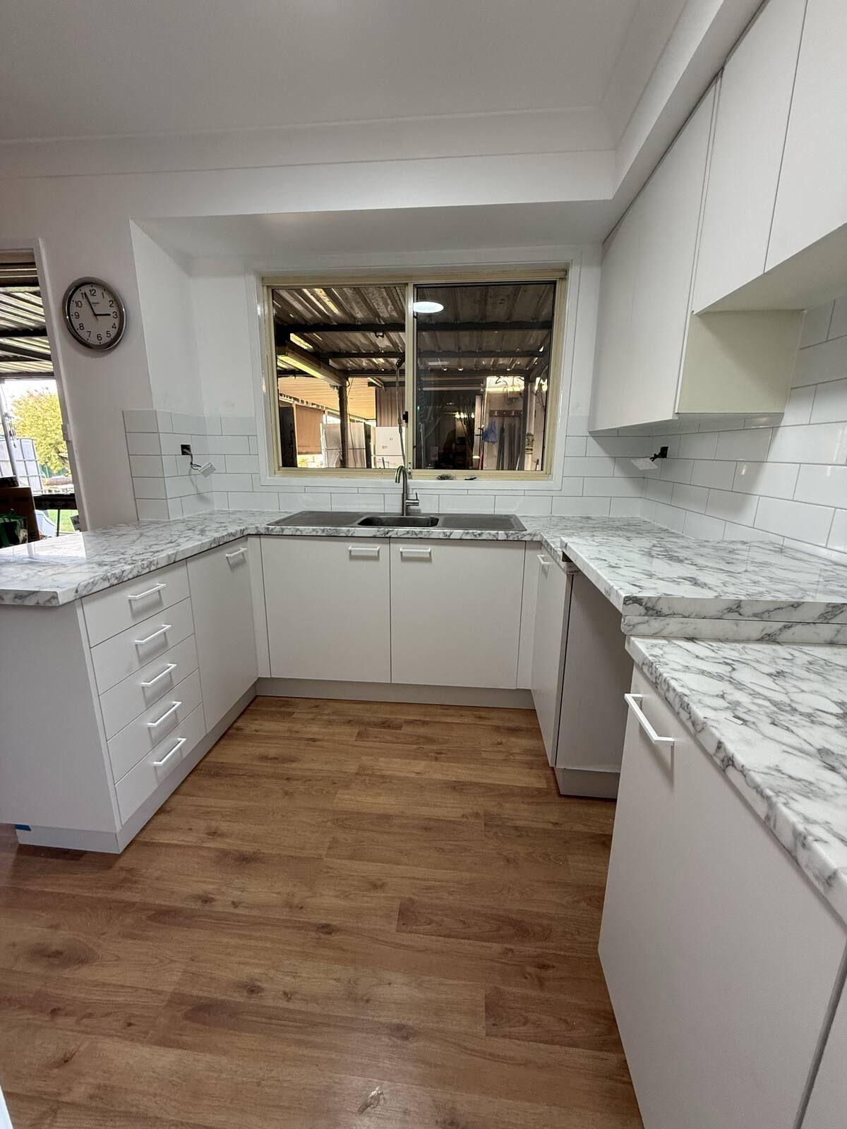 Kitchen renovation with marble-look stone benchtops, subway tile splashback and soft-close cabinetry
