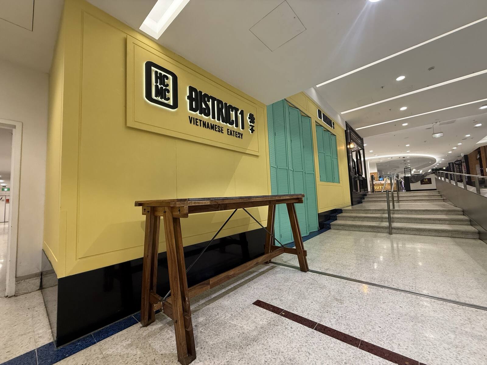 District 1 shopfront entrance within a Sydney shopping centre corridor